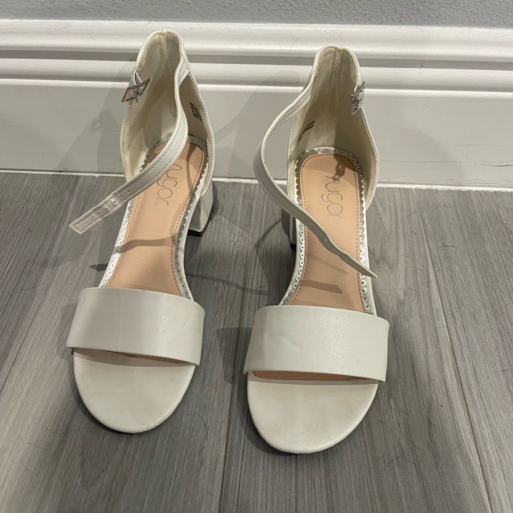 White, low chunk heel with ankle strap. Very comfortable. Size 8